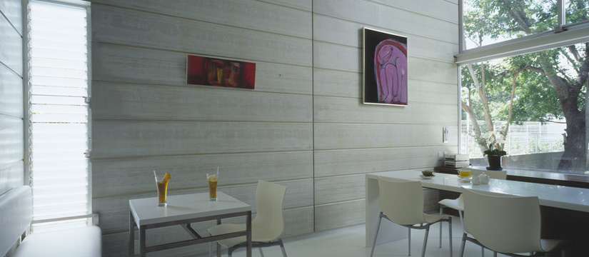 裏庭の緑が映り込む白い壁と床のカフェ